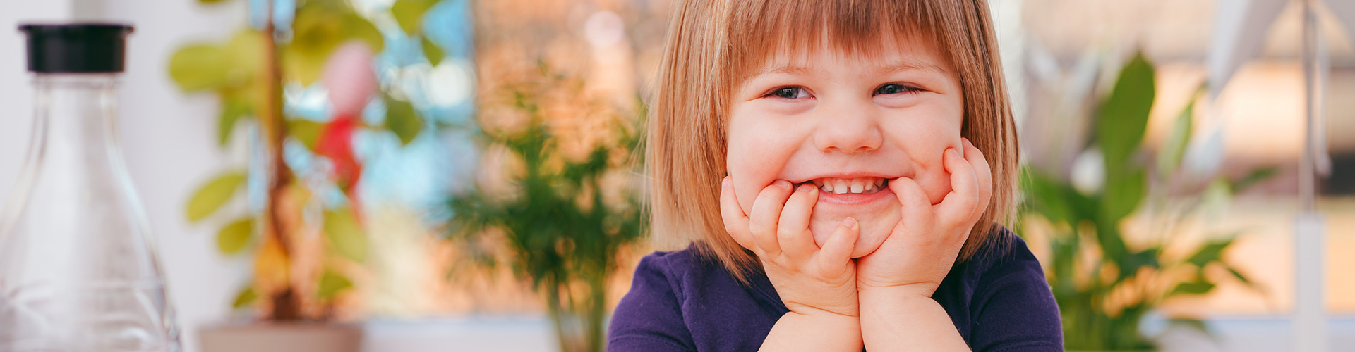 child smiling with head on hands.